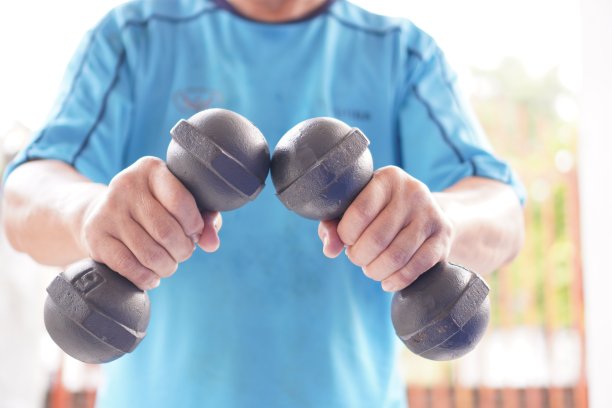 运动:图中展示的是两个哑铃的各种姿势的举重示范，特写，户外运动。图片下载