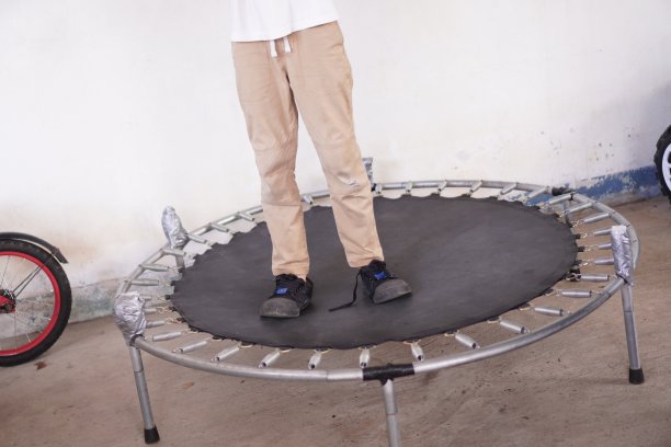 运动:孩子在家里玩蹦床的照片，户外。图片下载