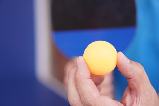 乒乓球:室内运动，近景，举着准备发球的乒乓球拍。图片下载
