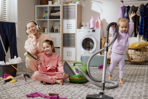 一家人在用吸尘器打扫房间。母亲和女儿打扫房子，扫地，拖地，擦地板在洗衣房，浴室。一边听音乐，一边和孩子们做家务图片下载