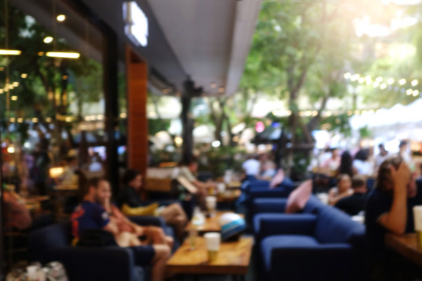 模糊抽象的背景户外咖啡馆或餐厅。户外咖啡馆，有桌椅。傍晚在现代露台上的街边咖啡馆。顾客们坐在咖啡馆外露台区域的桌子旁图片下载