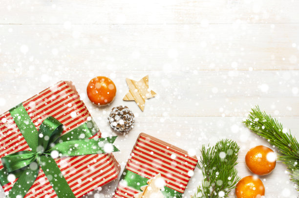 下雪的圣诞节组成。新年的木制玩具，礼品，冷杉球果，松枝，红球，礼品缠绕在白色木桌上，平铺俯视拷贝空间。圣诞冬季装饰，新年概念图片下载