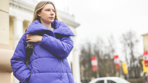 街上穿着紫色外套的漂亮女人的画像。图片下载