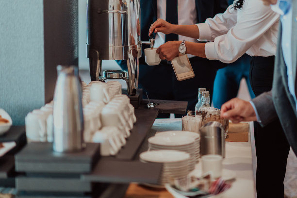 特写照片的商人服务自己在一个现代酒店的晚宴。有选择性的重点图片下载