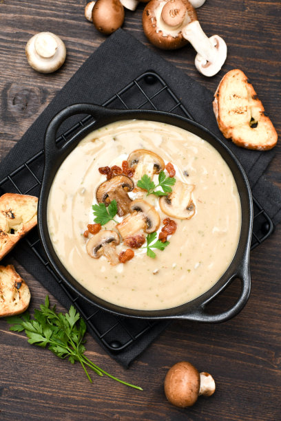 蘑菇汤，面包和新鲜的蘑菇在木制的背景图片下载