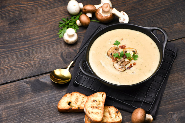 蘑菇汤，面包和新鲜的蘑菇在木制的背景图片下载