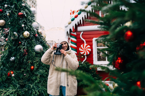 欢快的女人在节日冬季市场拍照图片下载
