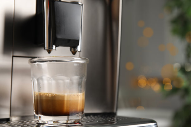 浓缩咖啡机与一杯新鲜的咖啡在滴盘上对模糊的背景，特写。空间的文本图片下载