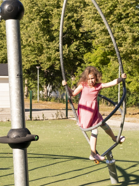 一个7岁的白人女孩在夏天的城市操场上玩耍。图片下载