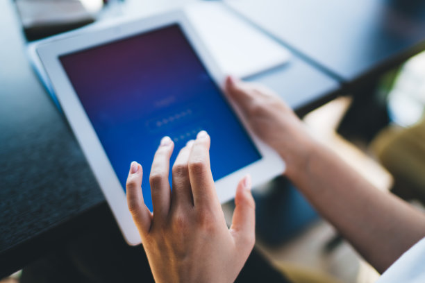 一张裁剪过的白人女人的照片。该公司的一款数字平板电脑连接到4G网络，轻按即可浏览网页，而女性则需要拿着触控板登录解锁图片下载