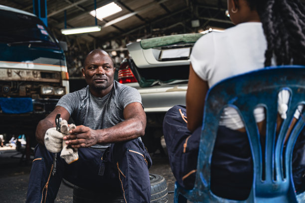 职业机械师休息时坐在车库里聊天。图片下载