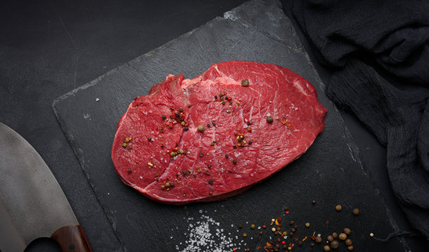 生的牛里脊放在一块黑桌子上。从上面的观点图片下载
