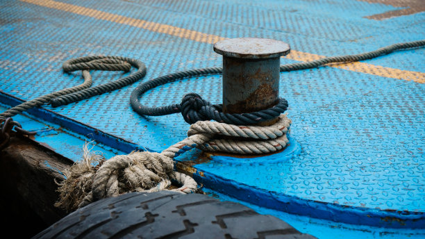 缆绳系在港口的一根大型钢系缆桩上图片下载