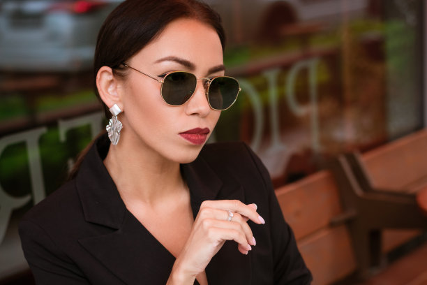 一位戴墨镜的女商人在咖啡馆的桌子旁的肖像图片下载