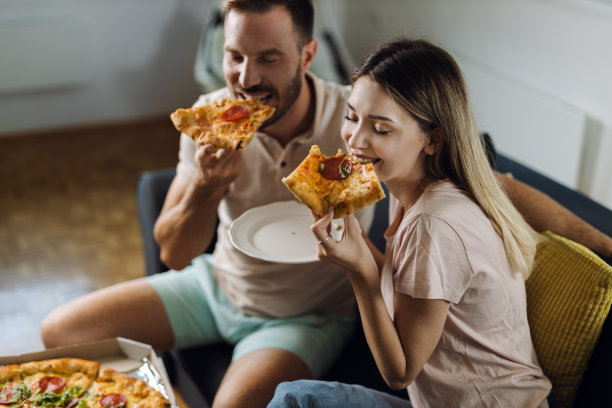 一对年轻夫妇在家里吃披萨图片下载