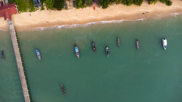 许多渔船靠近热带岛屿的海岸。泰国南部岛屿上村民的码头。无人机俯视图。图片下载