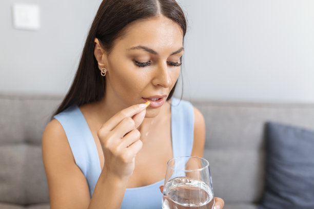 抑郁症妇女拿着药片和一杯水服用止痛药，补充维生素的药物，抗生素药物，老人概念的药物，近距离观察图片下载