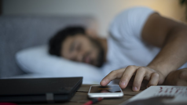 年轻人醒来，关掉手机上的闹钟图片下载