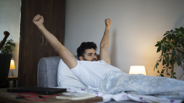 年轻人早上醒来，张开双臂向两侧图片下载