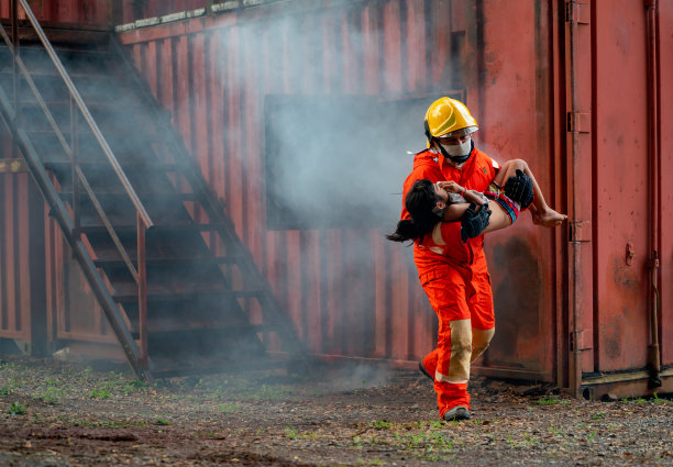 消防队员帮助小女孩从着火和烟雾弥漫的房间里出来，他带着孩子穿过房间的窗户，从大楼里跑了出来。图片下载