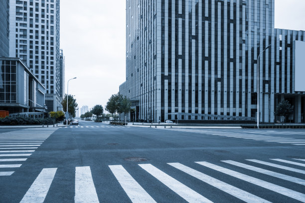现代城市里空荡荡的马路上有斑马线和摩天大楼图片下载