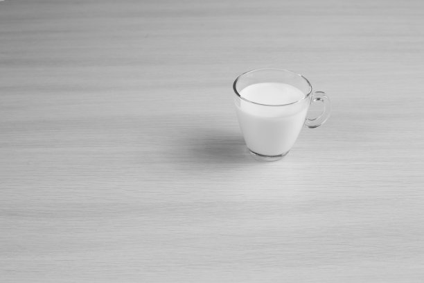 木桌面上的一杯新鲜牛奶。黑白照片图片下载