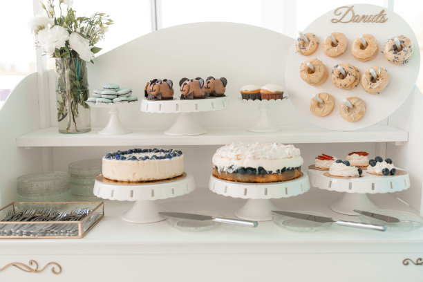 提供装饰甜甜圈，浆果蛋糕，饼干和奶油纸杯蛋糕托盘，白色背景。香甜烘焙的甜品，庆祝活动。自制的糕点，美味的食物，漂亮的服务图片下载