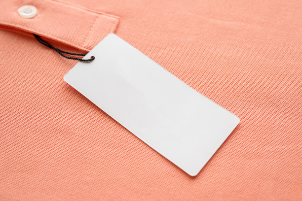 空白白色衣服标签标签上的粉红色织物纹理背景图片下载