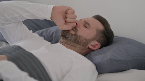 男子在床上睡觉时咳嗽图片下载