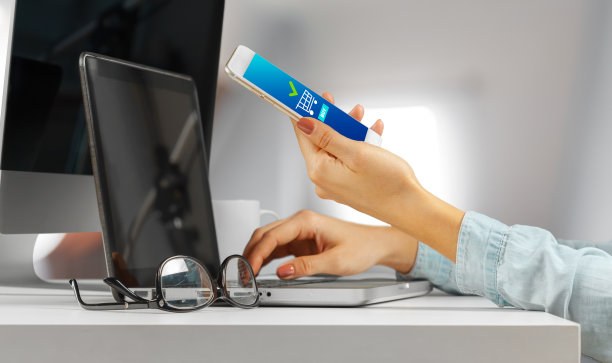 年轻女子坐在桌子与开放的上网本电脑。女性使用现代科技。图片下载