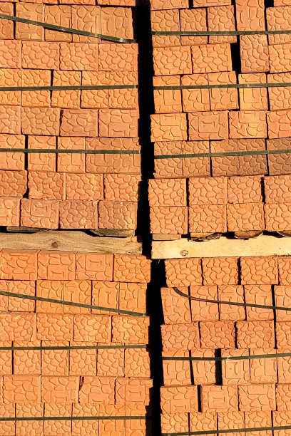 棕色砖块沿着建筑工地围栏堆放在托盘上图片下载