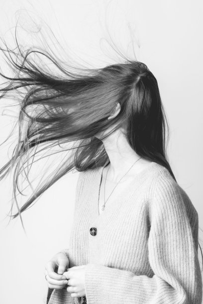 风吹女人的头发在明亮的工作室背景图片下载