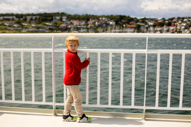 孩子们，在峡湾上乘坐渡轮，在阳光明媚的日子里在渡轮甲板上体验强风图片下载