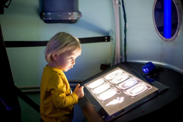 小男孩在宇宙飞船上，控制面板发光，孩子在扮演宇航员图片下载