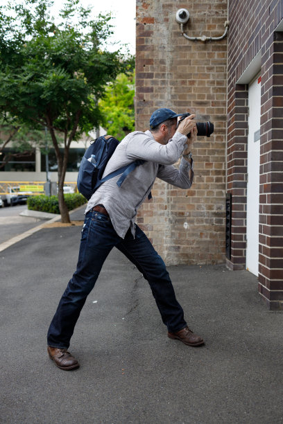 一名男子一边拍照，一边有摄像头监视。图片下载