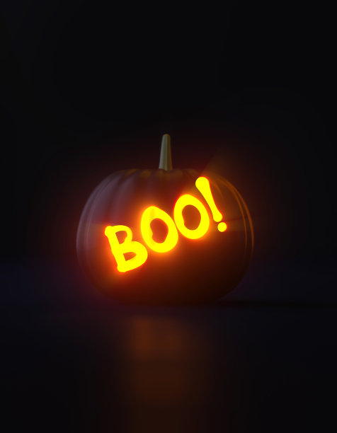 发光的Boo写的Jack O' Lantern在黑色背景上发光图片下载