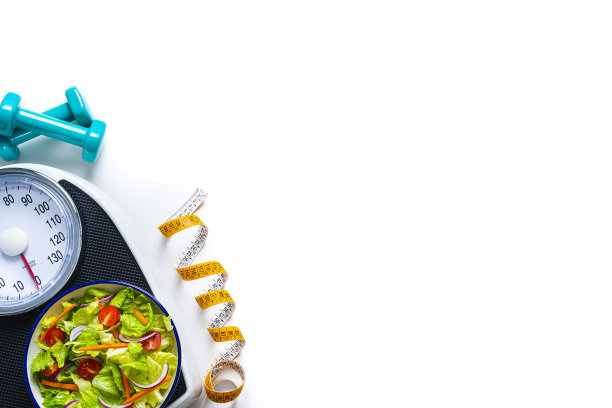磅秤上的沙拉碗。幸福的概念图片下载