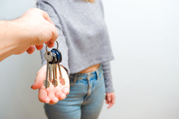 专注于女性手拿钥匙。女房地产经纪人给新房主一堆钱。手里拿着房子和一串钥匙。人们生活方式的概念。赠送钥匙图片下载
