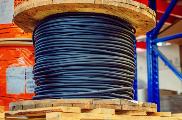 大木线轴与黑色电缆在工厂特写。图片下载