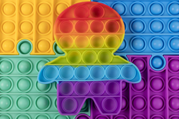 彩色指尖玩具POP IT的人形拼图背景。感官抗压力玩具，儿童和成人。素材图片