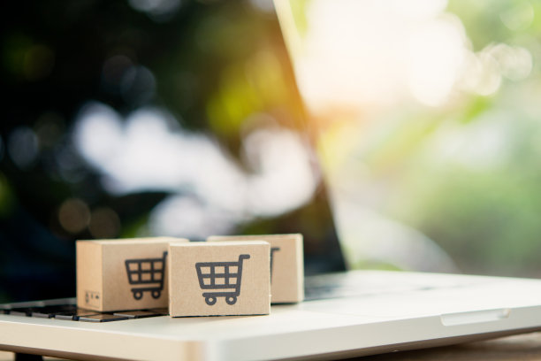 网上购物。笔记本电脑键盘上有购物车标志的纸板箱。网上购物服务。提供送货上门。本空间图片下载