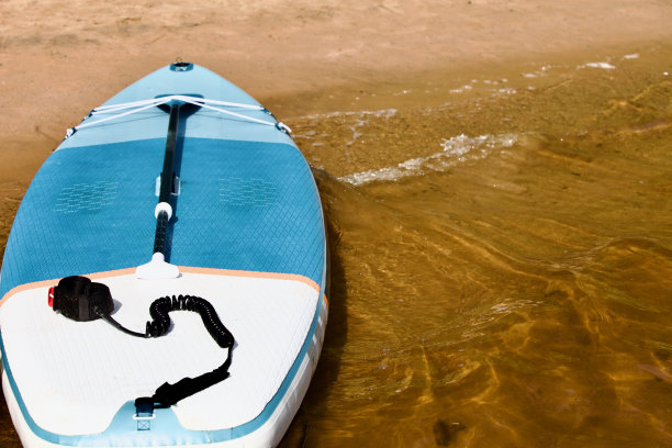 漂流SUP板和冲浪板与桨在沙滩岸边接近图片下载