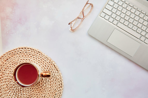 美观的家庭办公室:笔记本电脑，茶杯和眼镜。女性理念，远程工作，自由职业者，参加网络会议，视频电话家庭因为隔离的理念。复制空间，从上面看图片下载