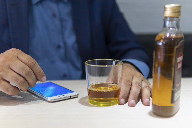 酗酒、酒精成瘾和人们在家里用一瓶朗姆酒来概念男性酗酒者。一个失业的专家，一个人因为无聊而喝醉图片下载