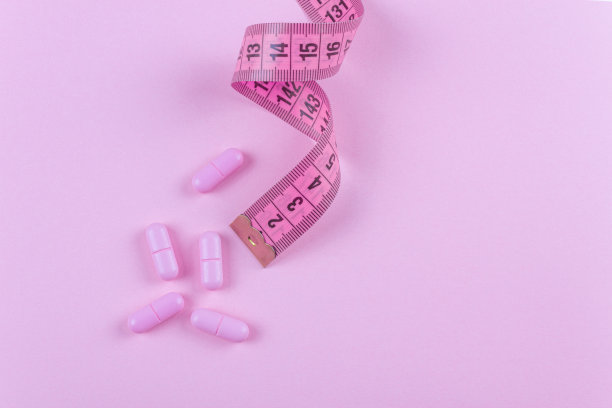 粉色背景上有粉色卷尺的药丸。图片下载