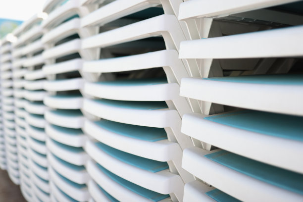 白色塑料躺椅堆叠在沙滩上图片下载