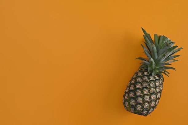 菠萝在黄色背景，顶部视图和复制空间。图片下载