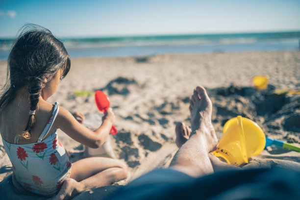 小女孩和她爸爸在沙滩上玩沙子图片下载