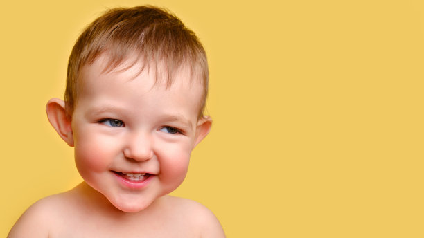 淘气的小孩，工作室黄色背景，拷贝空间。一个脸颊通红的阴险孩子的画像。孩子一岁两个月大图片下载