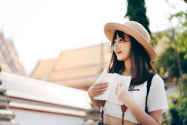 年轻的成年亚洲旅行妇女在标志性的寺庙户外的一天。曼谷,泰国。图片下载